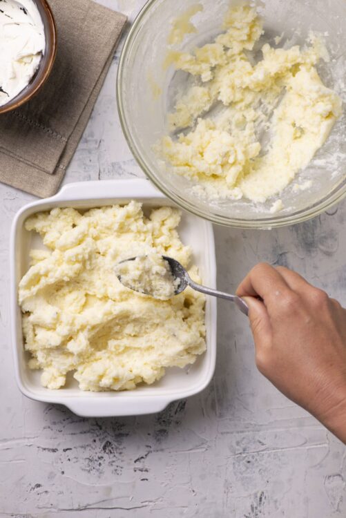 Creamy homemade mashed potatoes with butter in baking dish for comfort food recipes.