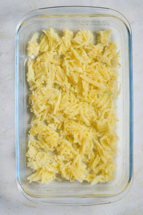 Shredded cheese in a glass baking dish for baked cheese casserole or cheesy baked dishes.