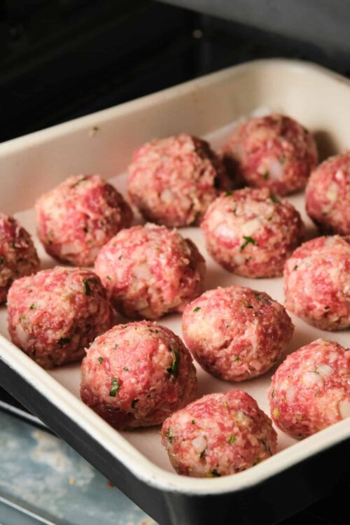 Minced meat mixture for meatballs in a baking dish.