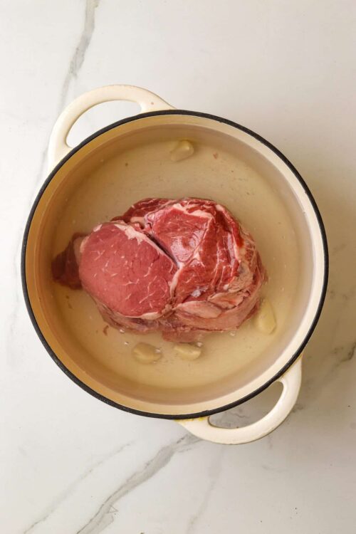 Raw beef roast in a roasting pan for cooking recipe.