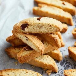 Butter cookies with almonds and chocolate chips on parchment paper.