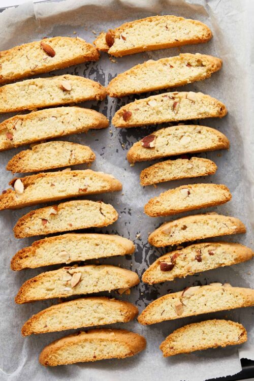Buttery almond biscotti with chopped almonds on parchment paper.