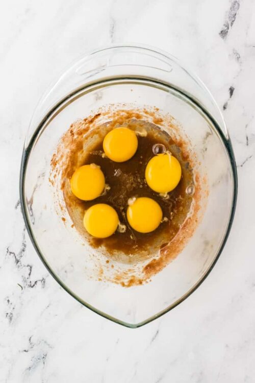 Beaten eggs in a glass mixing bowl for baking recipes.