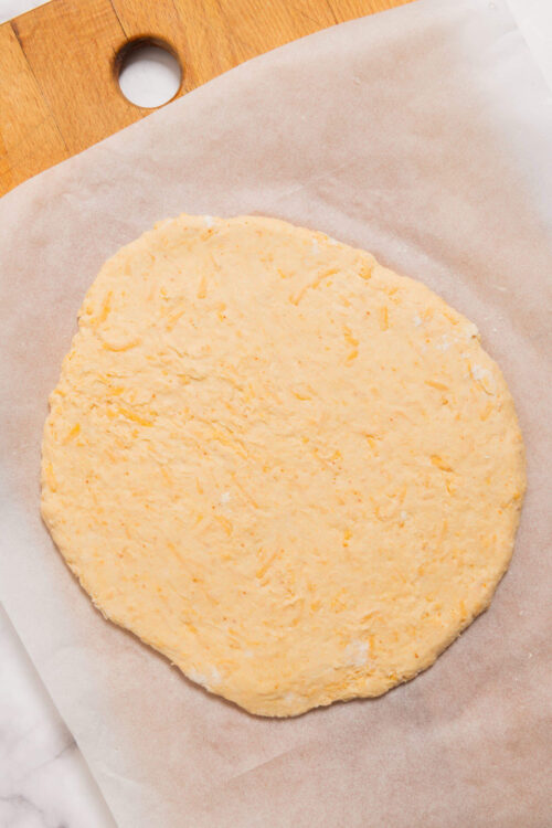Butter biscuit dough rolled out on parchment paper.