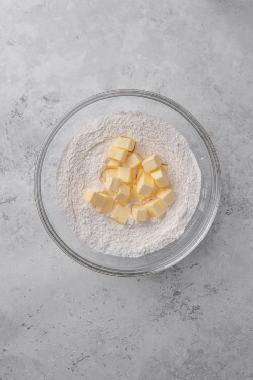 Flour and butter in a glass mixing bowl for baking recipes.