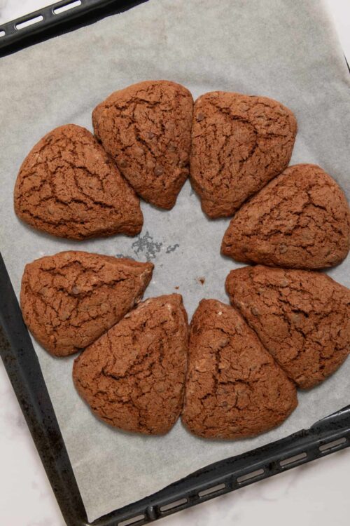 Chocolate chip cookies arranged in a circle on baking sheet.
