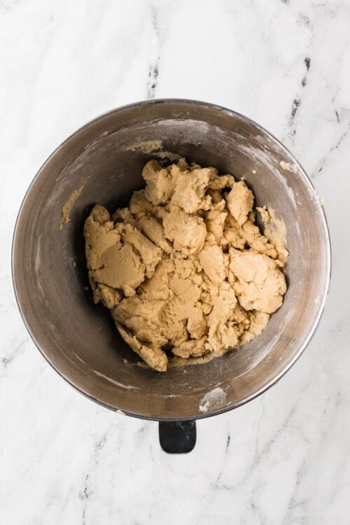 Buttery pie dough in a metal mixing bowl for baking recipes.