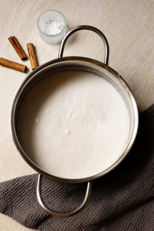 Cream of milk in a stainless steel pot for baking or cooking.