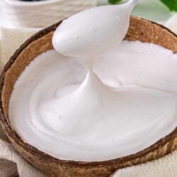 Fluffy homemade marshmallow in a rustic wooden bowl with fresh berries in the background.