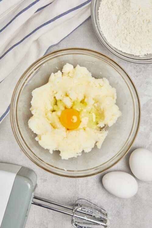 Creamy mashed potatoes with egg in a glass bowl for baking recipes.