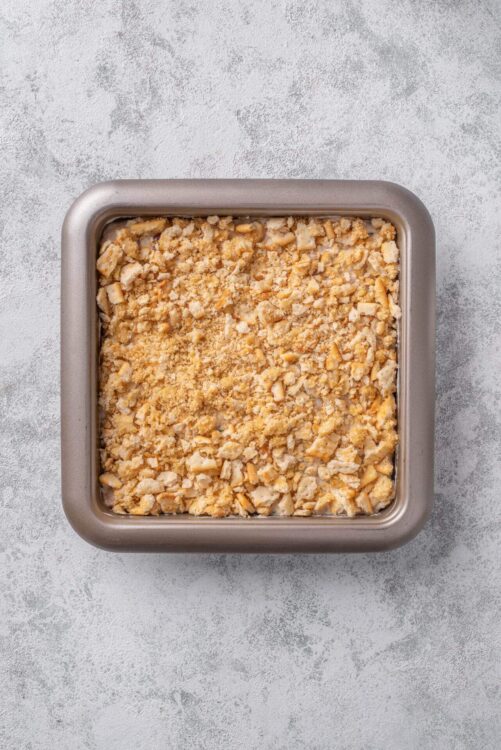 Crunchy crumble topping over baked fruit dessert in a square baking dish.