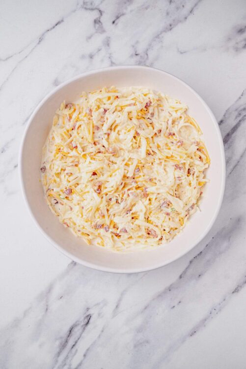 Creamy homemade macaroni and cheese in a white bowl on marble surface.