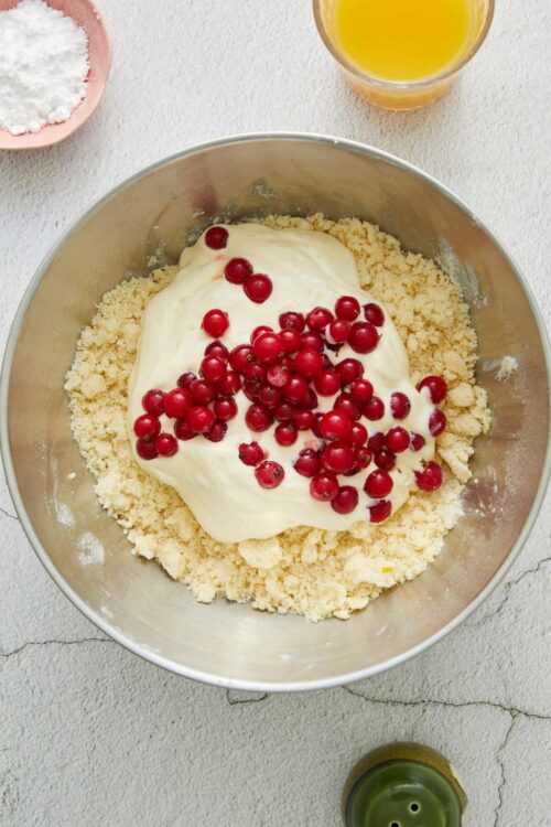 Crumbly pie crust with cranberry filling and creamy topping in a mixing bowl.