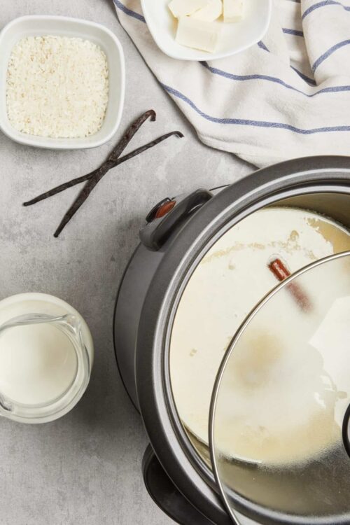 Vanilla bean spice custard in a slow cooker topped with cinnamon stick.