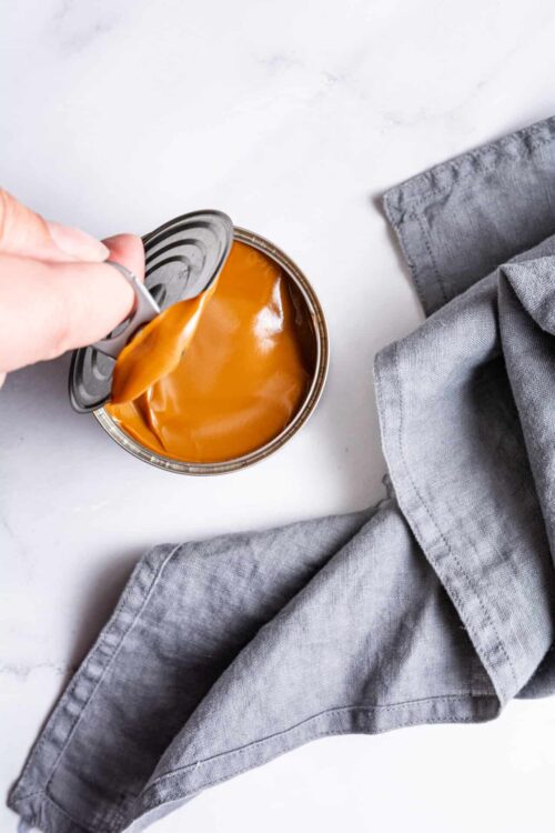 Sweetened condensed milk being opened for baking recipes.