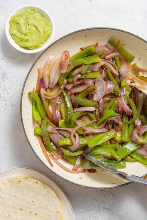 Sauteed sliced onions and green peppers, with creamy avocado dip on the side. Perfect for a quick, flavorful vegetable side dish.