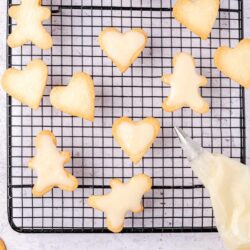 Butter cookies on cooling rack with vanilla icing drizzle.