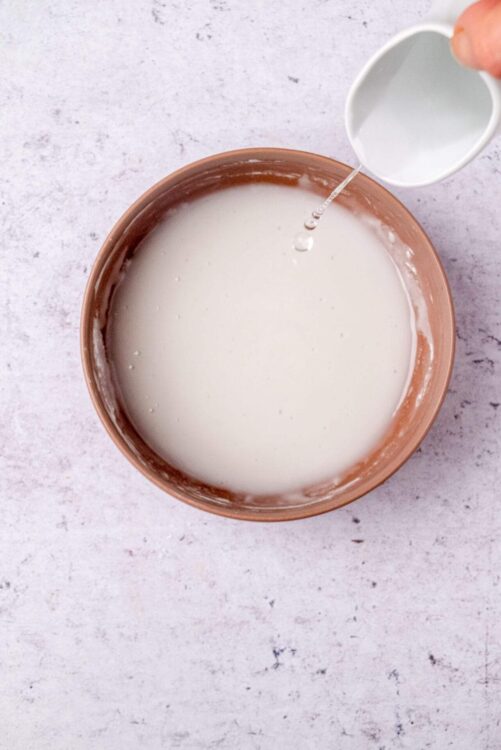Creamy milk being poured into a rustic bowl, perfect for baking recipes.