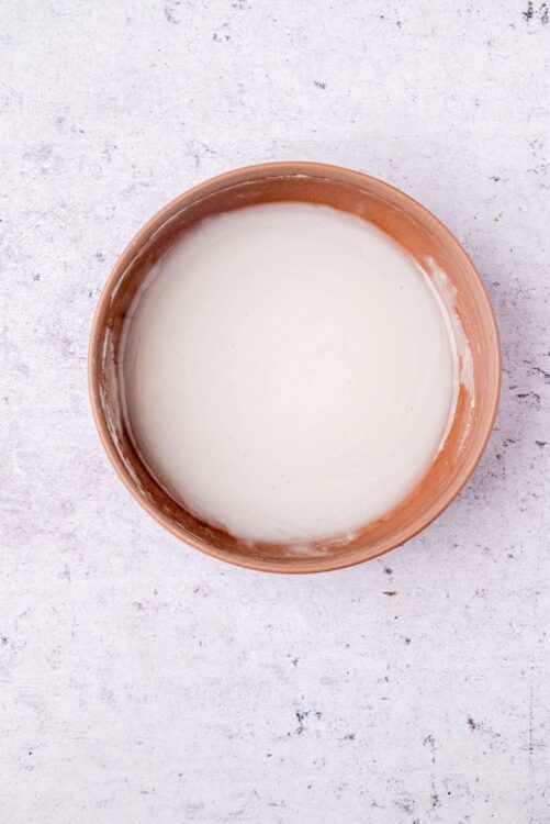 Cream in a rustic, terracotta bowl, perfect for baking and dessert recipes.