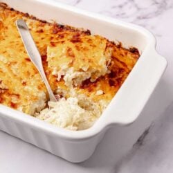 Creamy homemade chicken pot pie in a white baking dish with a golden crust.