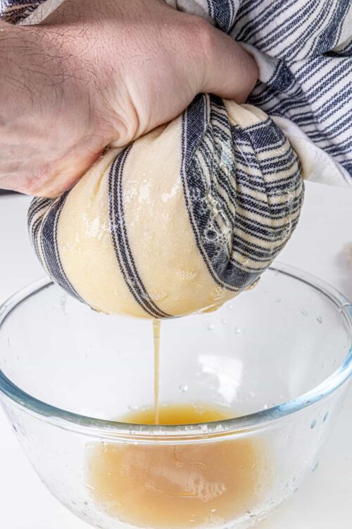 Baked-bree-squeezing-egg-into-bowl for baking and cooking ingredients, showing prep process, focus on eggs and kitchen tools.