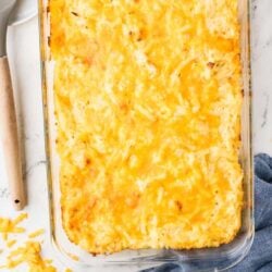 Baked cheesy potato casserole in a glass baking dish.