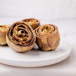 Roasted artichokes on a white plate, ideal for healthy recipes and delicious side dishes.