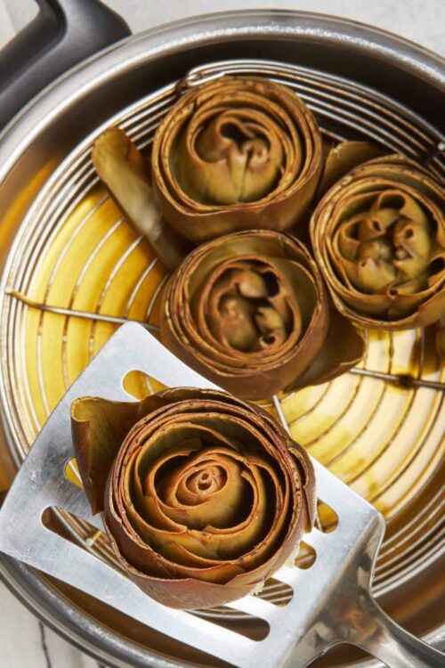Roasted artichokes in steamer basket.