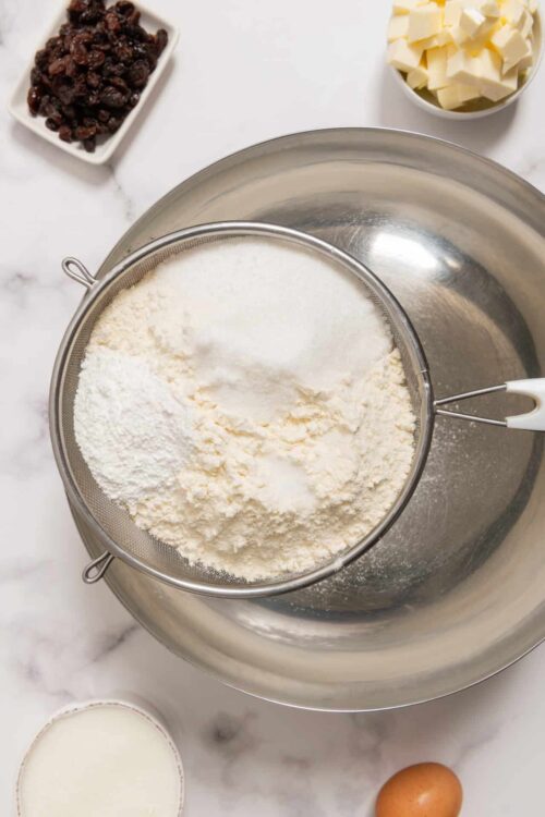 Flour and powdered sugar in a sifter over a mixing bowl for baking bread or cake.