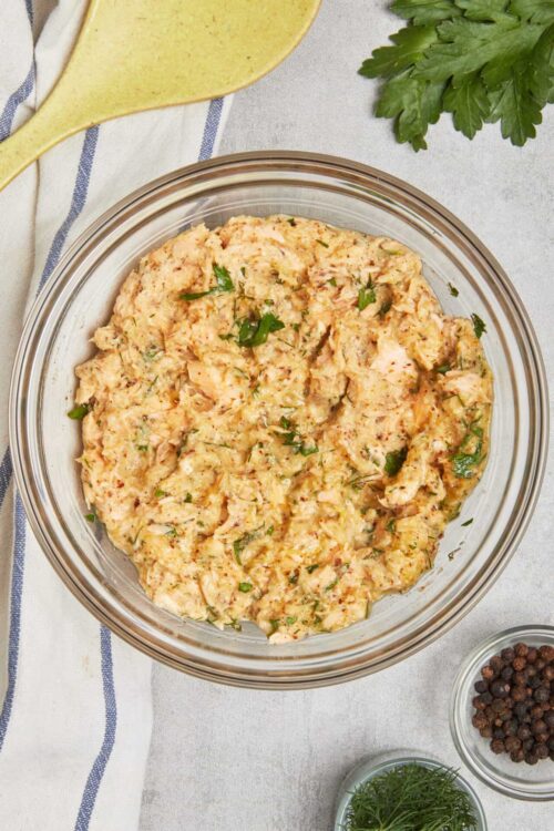 Creamy seafood dip with herbs in a glass bowl for appetizer or party.