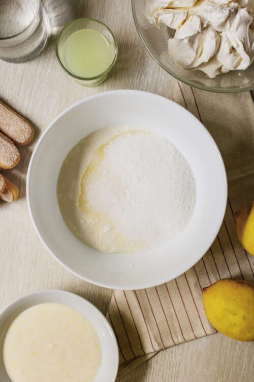 Flour, sugar, and ingredients for baking on a wooden surface.