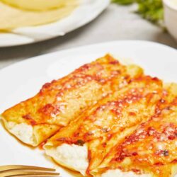 Delicious cheese ravioli with marinara sauce on a white plate.