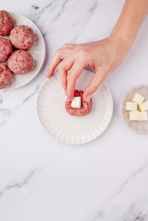 Juicy meatballs with white cheese on top, served on white plates. Perfect for baking and family dinner recipes.
