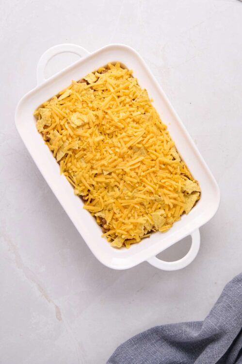 Cheesy baked casserole in white baking dish, savory comfort food.