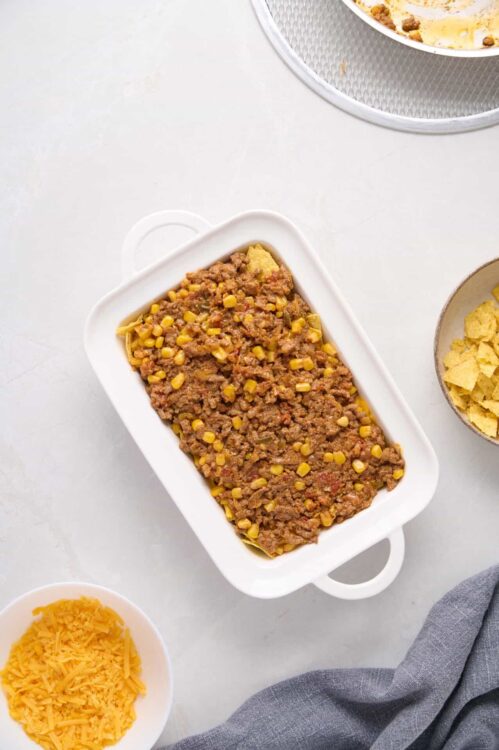 Savory ground beef and corn casserole in a white baking dish, ready to bake.