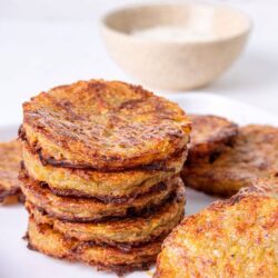 Crispy breakfast potato pancakes with golden brown edges on white plate.