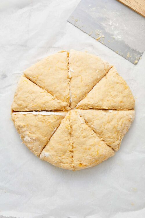 Buttery pastry dough ready for baking, cut into six pieces on parchment paper.