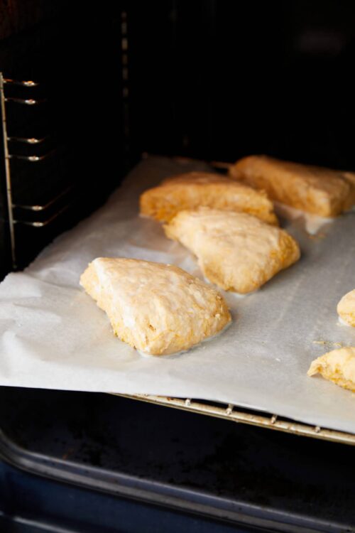 Buttermilk biscuits baking in oven, golden brown, flaky homemade biscuit recipe, baked goods from Baked Bree.