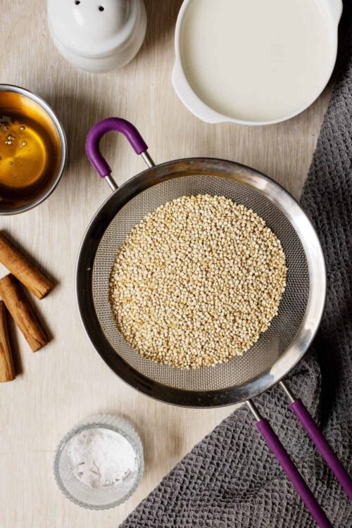 Raw millet in a fine mesh sieve for gluten-free recipes.