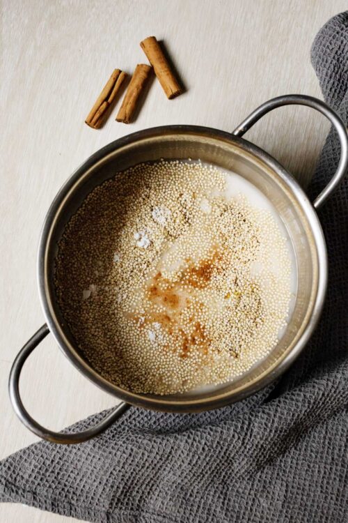 Cooking tapioca pearls in milk with cinnamon sticks on the countertop.