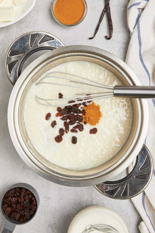 Cream cheese mixture with raisins, turmeric, and spices in a stainless steel bowl.