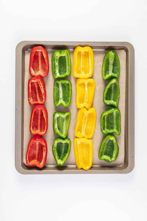 Colorful sliced bell peppers on a baking sheet for healthy cooking recipes.