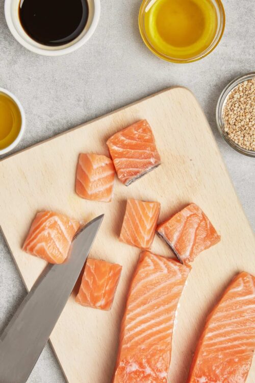 Fresh salmon fillets on a wooden cutting board, ready for cooking.