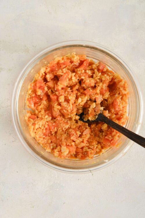Freshly mixed tomato and breadcrumb stuffing in a glass bowl for baked recipes.