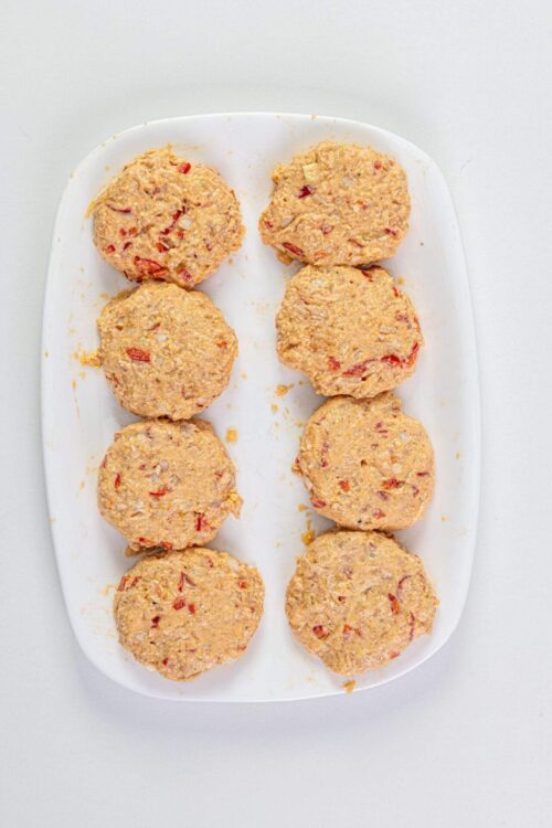 Creamy sausage and bell pepper mixture formed into patties ready for cooking. Perfect for breakfast or brunch dishes.
