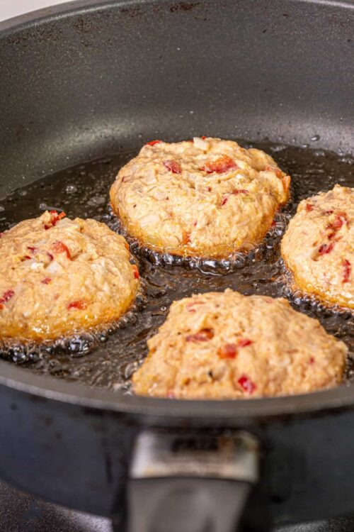 Juicy meatballs cooking in a skillet with hot oil, ready for serving or further sauce preparation.