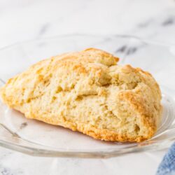 Buttermilk scone on a glass plate.