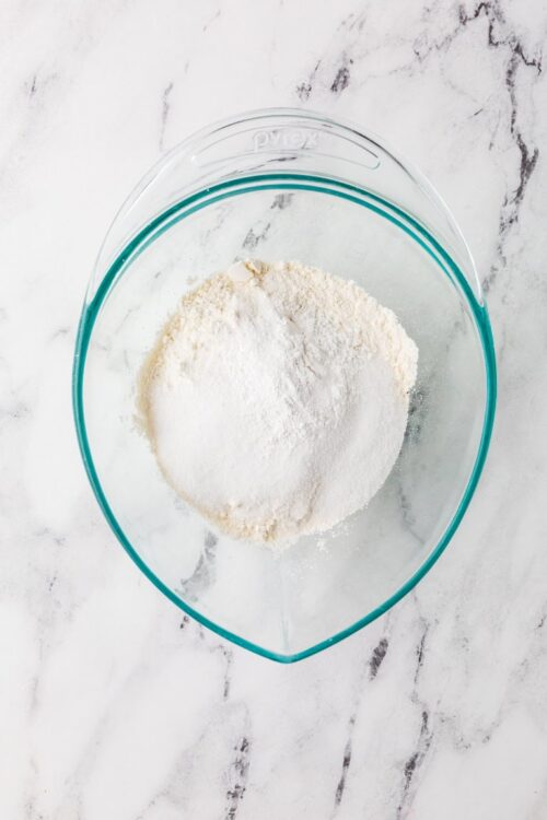 Flour and powdered sugar in a glass mixing bowl for baking recipes.
