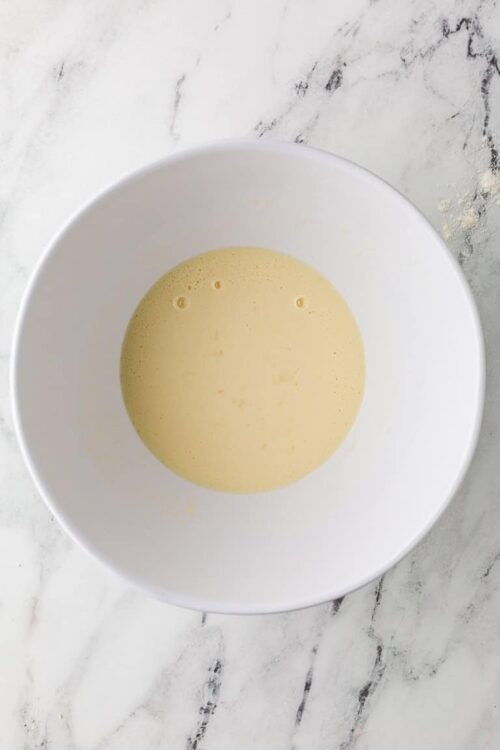 Smooth vanilla batter in white mixing bowl for baking recipes.