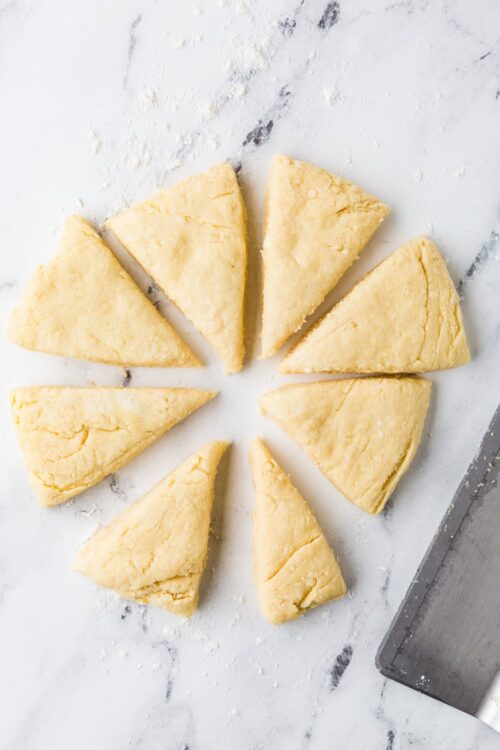 Buttery, homemade shortbread cookies cut into triangles on a white marble surface. Perfect for baking and dessert recipes.